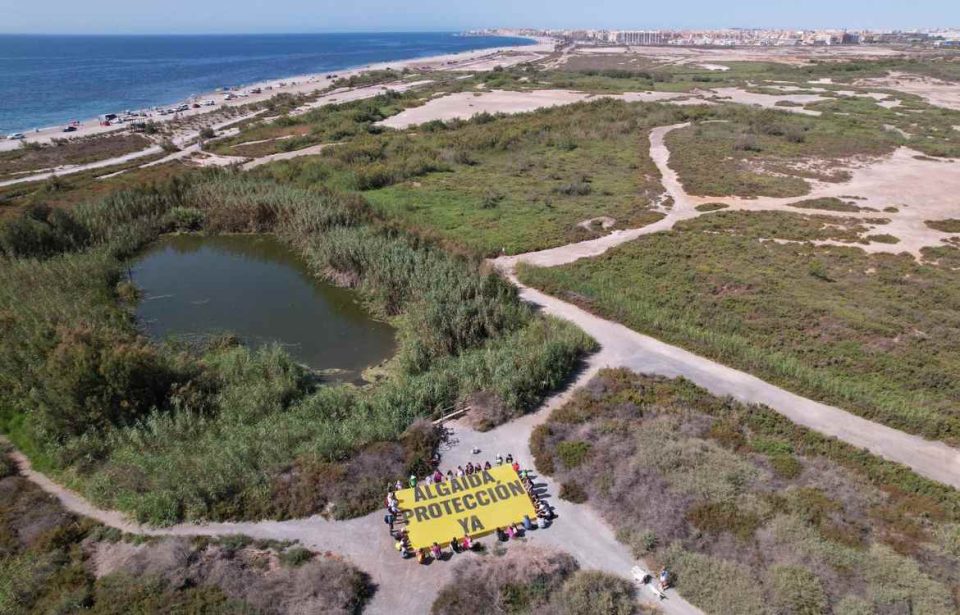 Activistas despliegan una pancarta en la Ribera de la Algaida de Roquetas para pedir la protección del humedal