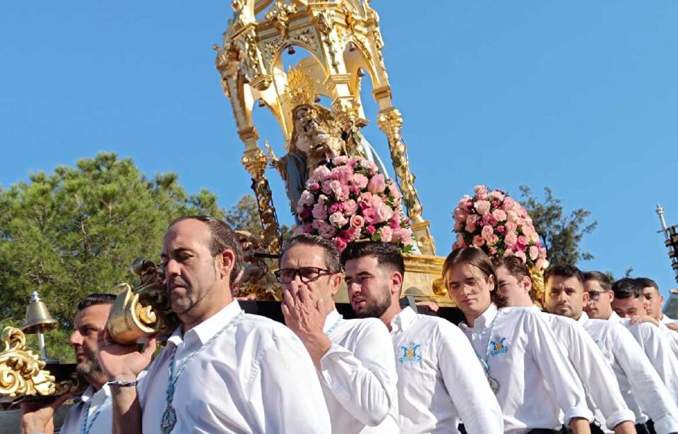 Multitud de personas acompañan a la Virgen de la Cruz en su subida hasta la Ermita en Benalmádena Pueblo