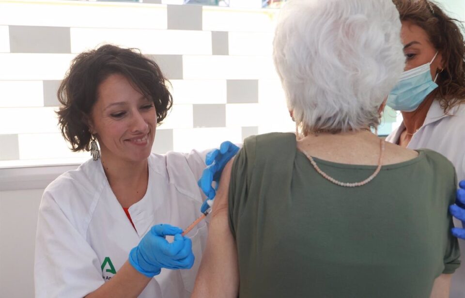 Una enfermera vacuna a una persona de edad avanzada.